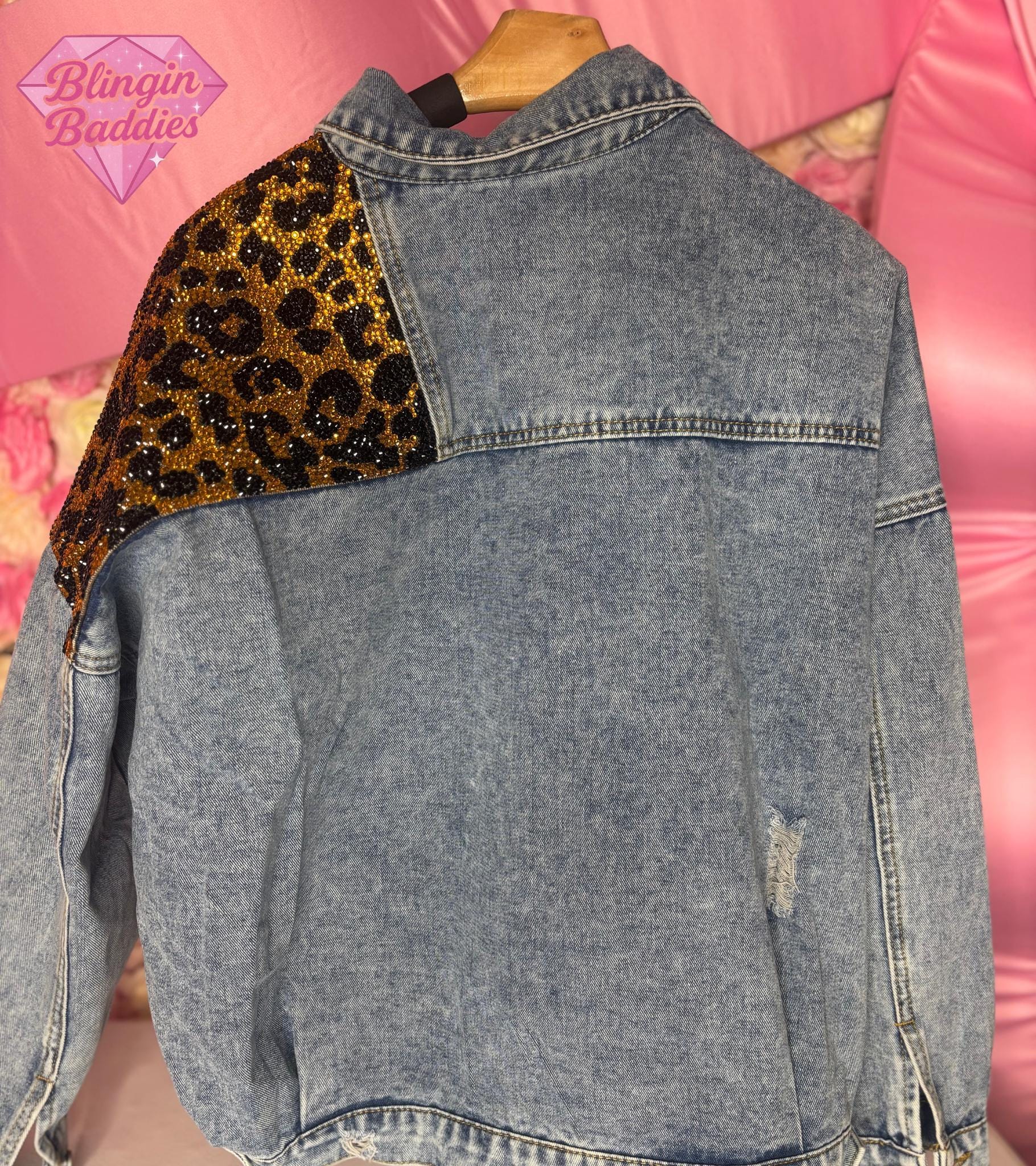 Back view of leopard rhinestone denim jacket showing crystal leopard shoulder panel on vintage wash denim