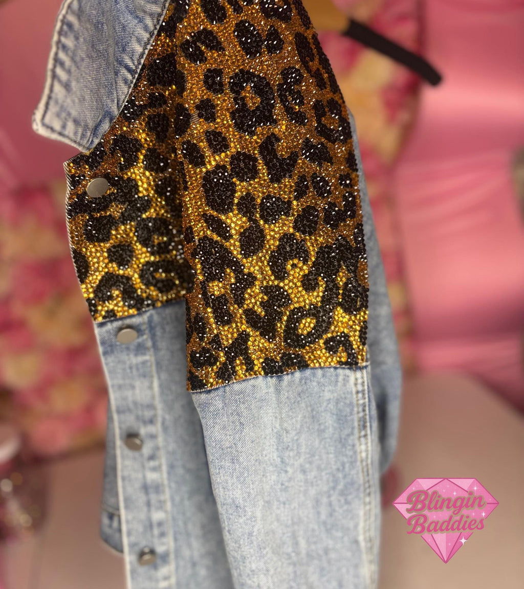 Close-up of gold and black rhinestone leopard print sleeve detail on denim jacket