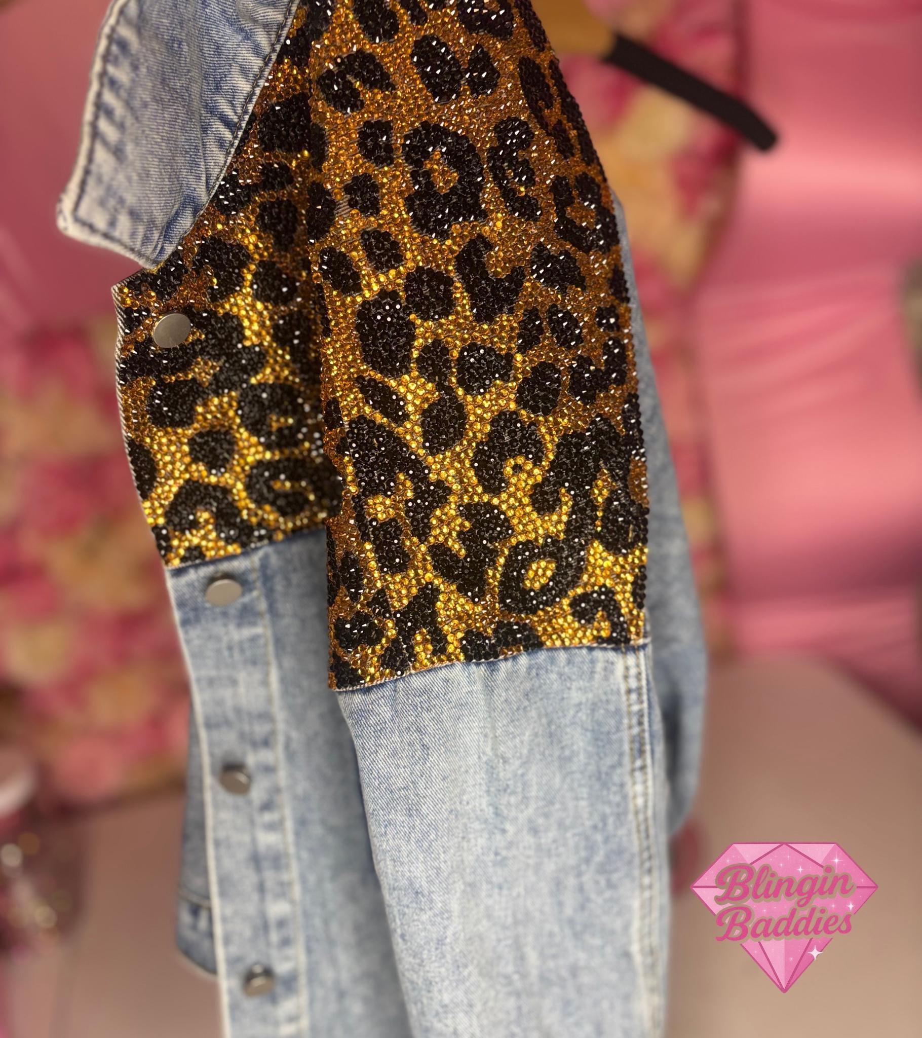 Close-up of gold and black rhinestone leopard print sleeve detail on denim jacket