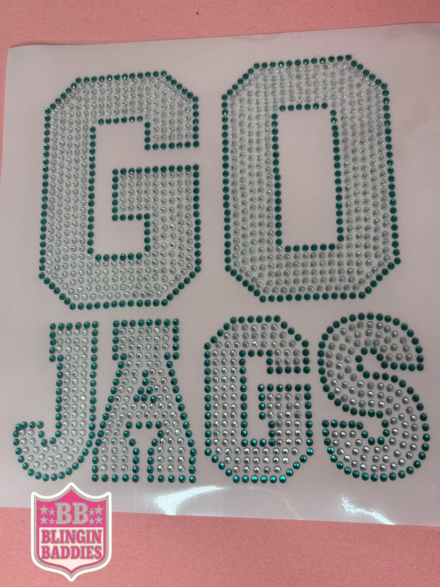 Close-up of GO JAGS teal and crystal rhinestone transfer sheet ready to heat press onto a shirt