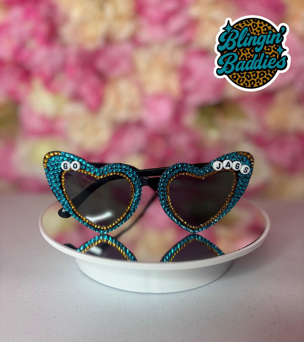 GO JAGS rhinestone heart sunglasses with teal crystals and gold accents on white dish, Jaguars game day bling